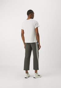 adidas Sportswear FUTURE ICONS - Jogginghose - legend ivy