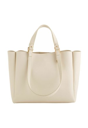 Beżowa torba typu tote ze skórzanymi, sztywnymi bokami, dwoma paskami na ramię oraz złotymi ozdobami.