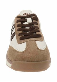 Sneaker bianco e marrone con materiali in pelle scamosciata e pelle, dotata di lacci marroni, punta rotonda e un sottile dettaglio del logo. La suola è in gomma.