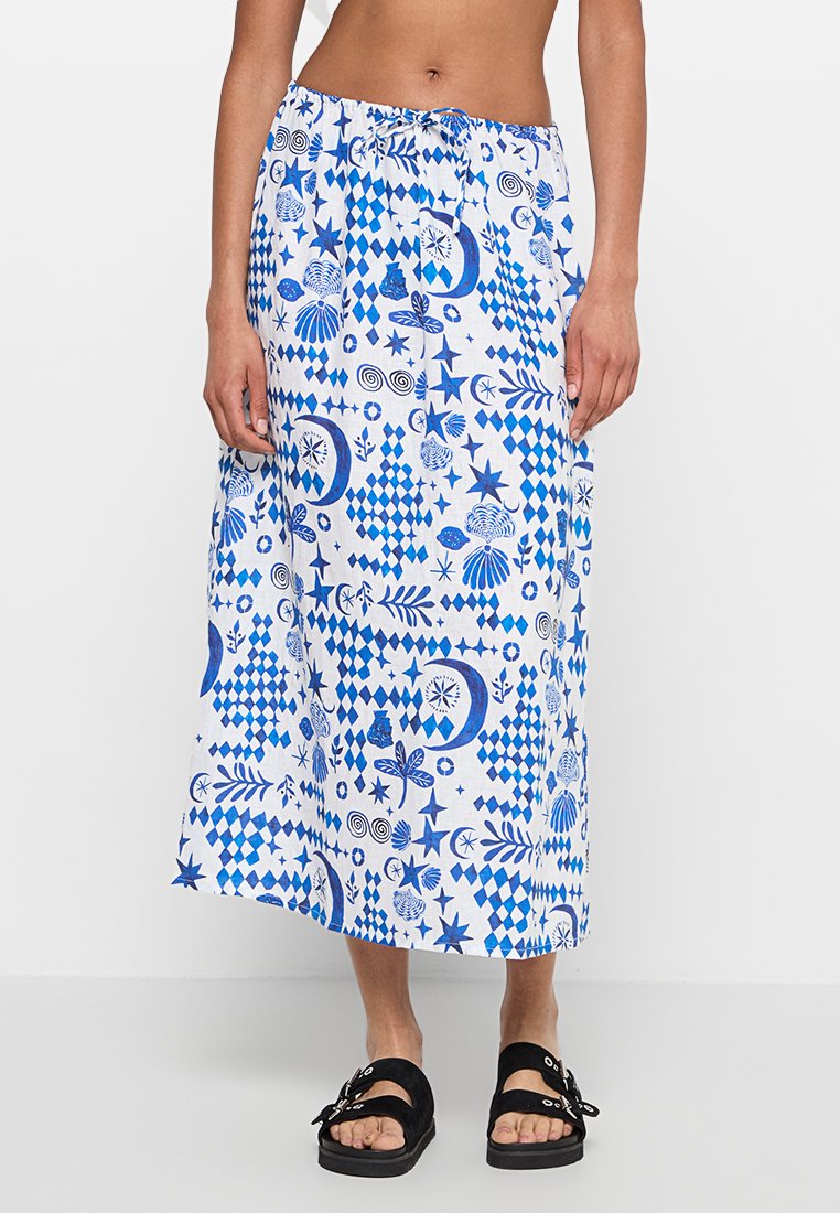 Larga falda blanca con un patrón abstracto azul que incluye estrellas, flores y conchas. Cintura elástica con cordón.
