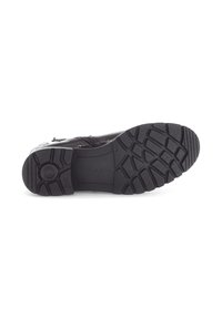 Semelle de chaussure en caoutchouc noir avec un motif de semelle texturé, présentant un emblème circulaire et la marque "Gabor" en relief sur la surface.