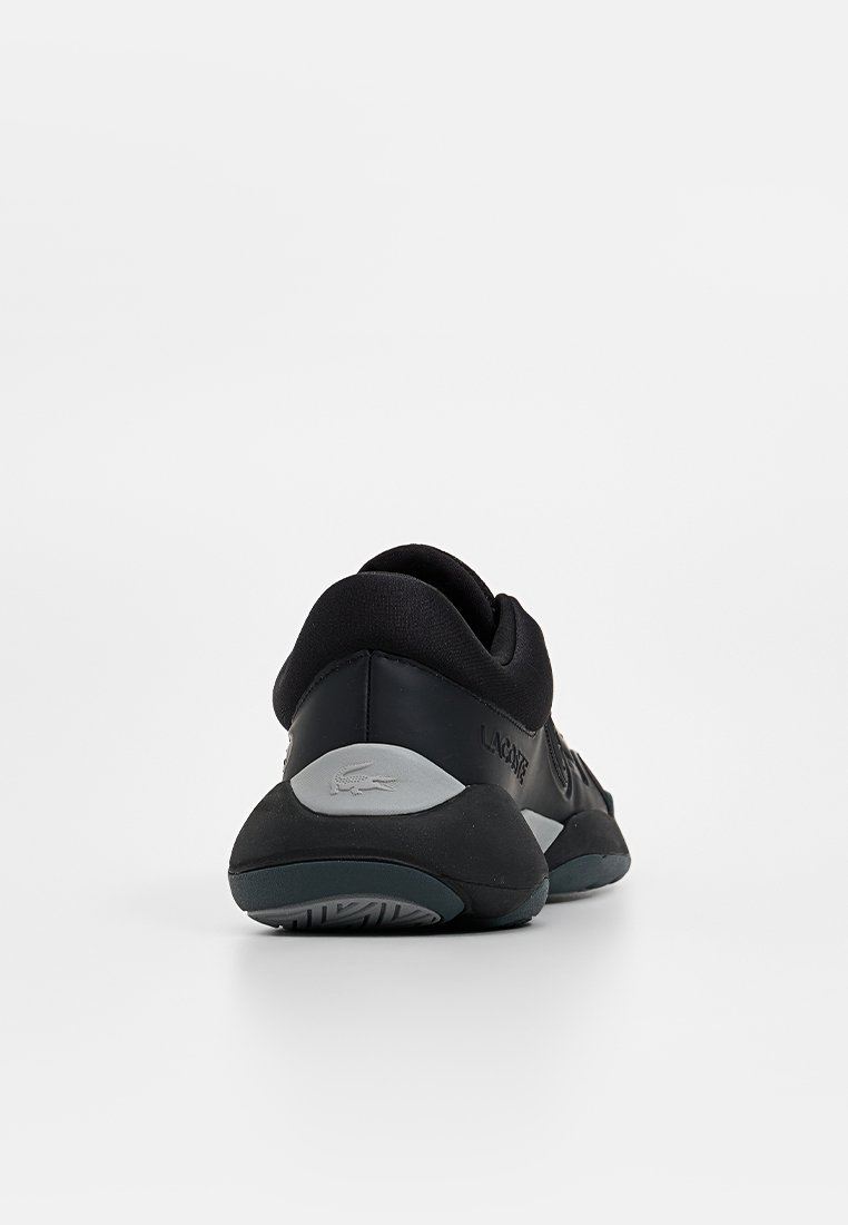 Black athletic shoe with a smooth upper, padded collar, and grey accents. Features a textured rubber sole with a logo on the side.