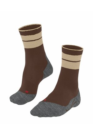 Chaussettes marron avec un design rayé beige autour du poignet et une section de pied grise texturée. Accent rouge sur le côté.