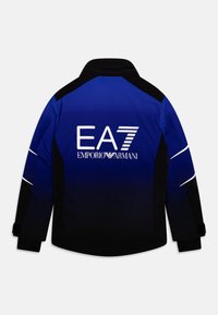 Blue and black jacket with a gradient design, featuring "EA7" and "Emporio Armani" logos, reflective accents, and velcro cuffs.
