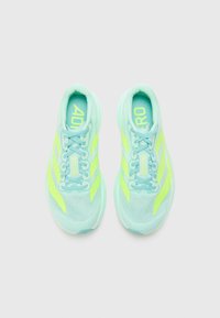 Helleblaue Sportschuhe mit gelben Akzenten, Mesh-Obermaterial und strukturiertem Design. Verfügt über ein Schnürsystem und eine gepolsterte Sohle für Unterstützung.