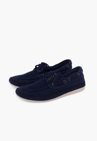 Navy canvas shoes with a rounded toe, lace-up design, gold eyelets, and a white rubber sole. Features stitched detailing and a textured finish.
