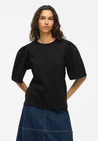 Črna kratka majica z okroglim izrezom in nabranimi rokavi, izdelana iz gladkega materiala z oprijetim krojem.