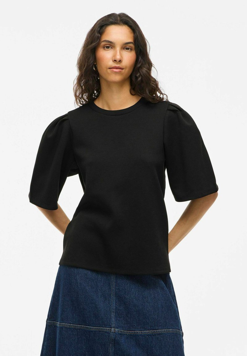 Črna kratka majica z okroglim izrezom in nabranimi rokavi, izdelana iz gladkega materiala z oprijetim krojem.