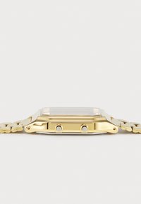 Χρυσό μεταλλικό ρολόι με ορθογώνια κάσα, δύο κουμπιά στο πλάι και χρυσό βραχιόλι που ταιριάζει. Μινιμαλιστικός σχεδιασμός και γυαλιστερή φινιρίσματος.