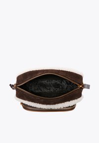 Brązowa zamszowa torba z białym futrzanym wykończeniem, złotym zamek błyskawiczny i wzorzystą czarną podszewką. Otwarta torba ukazuje przestronną powierzchnię wnętrza.