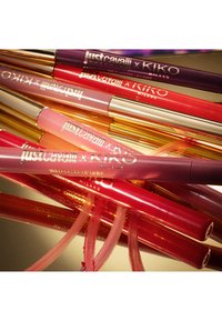 Just Cavalli x Kiko Milano lip liners in various shades, arranged on a reflective surface with color swatches visible.