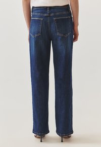Jeans de mezclilla azul oscuro con un diseño de pierna recta, que presentan dos bolsillos traseros y una textura ligeramente desgastada. Acento de hardware de acero.