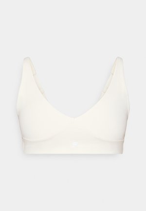 Svetlo bež, brezšivni modrček z V-izrezom, širokimi naramnicami in subtilnim logotipom spredaj. Narejen iz gladkega, raztegljivega materiala.