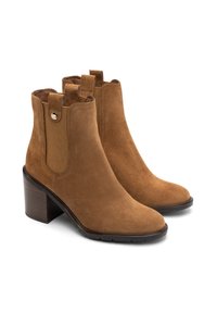 Zamszowe botki do kostki w odcieniu brązowym, z okrągłym noskiem, bocznymi elastycznymi panelami, pętelkami do zakładania oraz brązowym, warstwowym obcasem dla dodatkowej wysokości i stabilności.