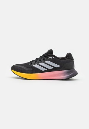 Sort atletiksko med hvide striber og en gradient sål, der går fra gul til pink til lilla, vist i højre side.