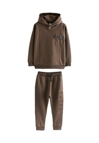 Brun hoodie med en frontlomme og snøre, parret med matchende sweatpants med "BAKER" prægning på siden. Blød stofstruktur.