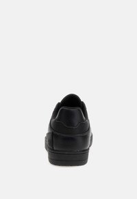 Sneaker nera con tomaia in pelle testurizzata, punta arrotondata e design a profilo basso con colletto imbottito e sottili accenti del logo.
