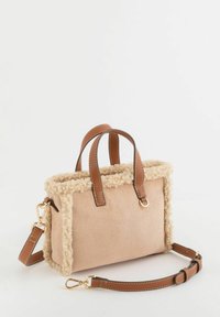 Bolso beige con ribete de borreguito sintético, asas de cuero marrón y correa desmontable. Cuenta con herrajes dorados y textura suave.