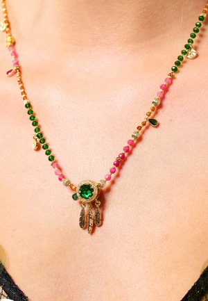 Collier coloré constitué de perles vertes, roses et dorées, avec une pierre centrale ressemblant à une émeraude et des accents en métal en forme de plumes suspendus.