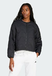 Černá prošívaná krátká bunda s dlouhými rukávy, která má přední zip a jemný vlnitý vzor; hladká textura a lehký design.