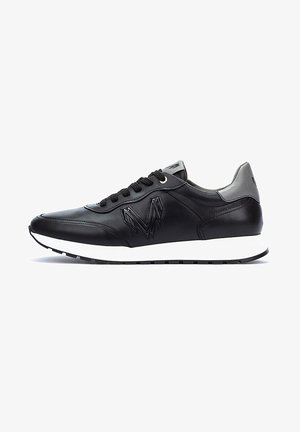 Zapatillas de cuero negro con superficie texturizada, que cuentan con una entresuela blanca, cordones negros y un acento en el talón de color gris. Logo distintivo en el lado.