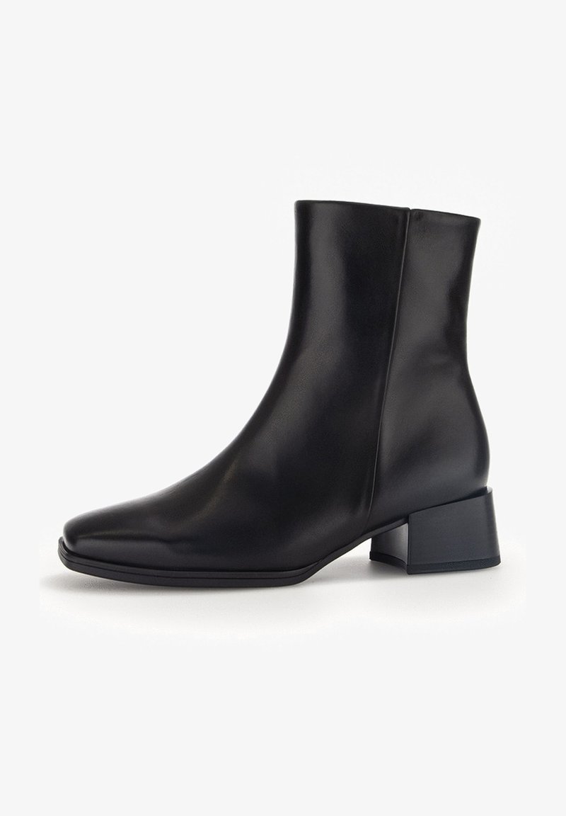 Bottes chevilles en cuir noir avec bout pointu, design élégant et talon bloc épais. Texture lisse, détails minimalistes, silhouette moderne.