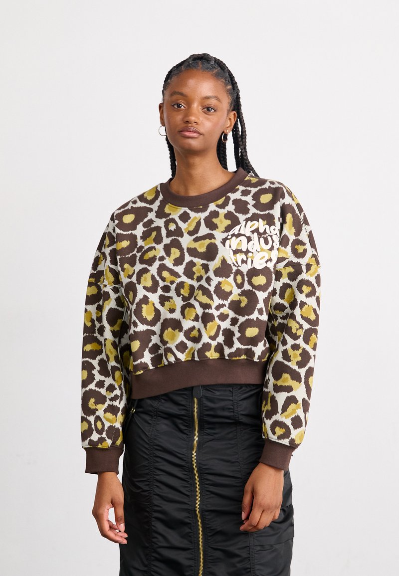 Hnedý skrátený mikina so žltým a čiernym leopardím vzorom, s kruhovým výstrihom a bielym logom na prednej strane.