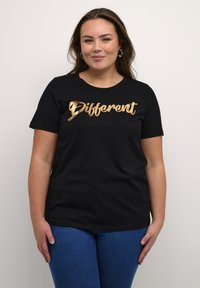 Svart bomulls t-shirt med korta ärmar, med guld folie-texten "Different" i kursiv stil, rund halsringning och en avslappnad passform.