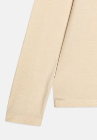 Beige langermet skjorte laget av et mykt, teksturert stoff. Har en rund hals og enkle hemmede ermer.