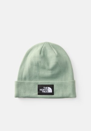 Beanie verde chiaro, texture a coste, con risvolto, caratterizzato da una patch rettangolare nera con dettagli del logo bianchi.