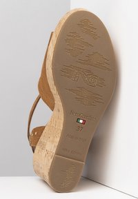 Braune Wildleder-Wedge-Sandalette mit Korksohle. Sie verfügt über eine strukturierten Gummiboden, ein geprägtes Logo, die italienische Flagge und die Größe 37 aufgedruckt.