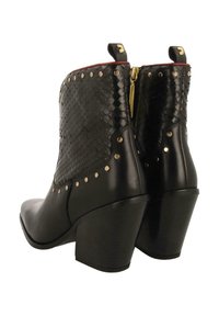 Botas negras hasta el tobillo con un patrón de serpiente texturizado, tachuelas doradas y una cremallera. Cuentan con un robusto tacón cuadrado y un acabado en cuero suave.