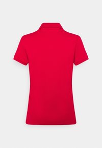 T-shirt polo rouge à manches courtes, avec un col replié et une finition lisse et texturée. Dos uni sans logo ni motifs visibles.
