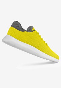 Gelber Mesh-Sneaker mit grauen Akzenten, ausgestattet mit einer abgerundeten Spitze, sechs Ösen und einer weißen Gummisohle. Leichtes Design für Komfort.