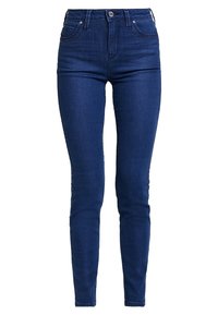 Pantalones vaqueros pitillo de tiro medio en color azul índigo, hechos de mezclilla elástica, con una textura suave, diseño de cinco bolsillos y cierre frontal con botones.