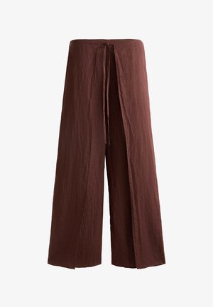 Pantaloni a gamba larga in marrone intenso, realizzati in un tessuto testurizzato con vita regolabile tramite coulisse e spacchi frontali per facilitare il movimento.