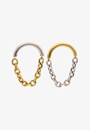 Twee metalen kettingoorbellen met halvemaanvormige topjes, de ene gouden ketting met zilveren top, de andere zilveren ketting met gouden top, op een witte achtergrond.
