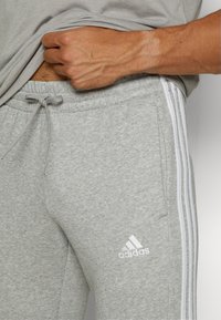 adidas Sportswear ESSENTIALS TAPERED CUFF 3-STRIPES  - Treniņtērpa apakšdaļas - medium grey heather