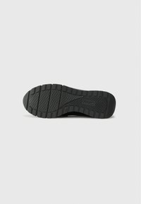 Black rubber shoe sole with textured grip, featuring ridges and a patterned surface for traction and stability. Lightweight design.