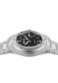 Zilveren roestvrijstalen horloge met een octagonale kast, zwarte skeleton wijzerplaat, zilveren wijzers en een schakelarmband ontwerp. Automatische beweging zichtbaar.