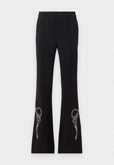 Μαύρο παντελόνι καμπάνα με λευκή κεντητή μοτίβα λουλουδιών κοντά στο τελείωμα και στα δύο πόδια, με χαρακτηριστικά πιέτες μπροστά και θηλιές για ζώνη.