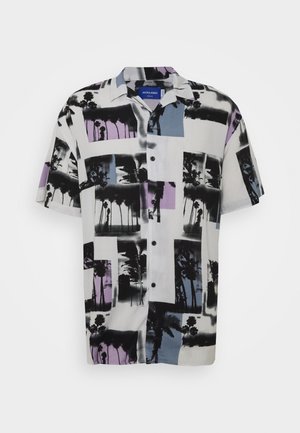 Camicia a maniche corte con bottoni, decorata con motivi di palme nere su tessuto bianco, evidenziata da blocchi di colore rettangolari viola e blu.