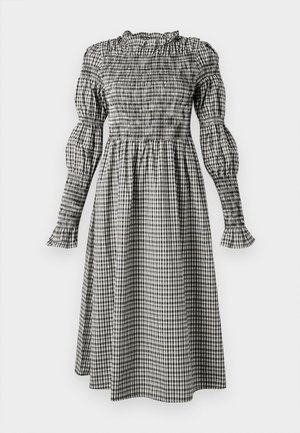 Zwart-wit geruite jurk met een smock-bustier, poffende lange mouwen, gerimpelde manchetten en een vloeiende, knielange rok.