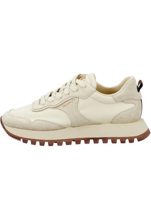 Baskets couleur crème avec un mélange de cuir lisse et de daim. Présentent une semelle texturée, un design à lacets et un logo subtil sur le côté.