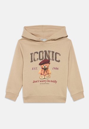 Smėlio spalvos vaikiškas džemperis su kapišonu, ant kurio pavaizduotas meškiukas su raudona berete ir užrašais: „ICONIC“, „EST. 1986“ ir „Don't worry be teddy.“