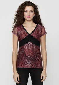 Top corto rosso e nero a manica corta con scollatura a V, motivo testurizzato e dettagli neri sul décolleté. Tessuto liscio con un design aderente.