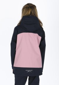 Waterproof jacket in navy and pink. Features a hood, long sleeves, and logo at the lower back. Smooth texture and modern design.