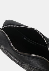 Borsa a pochette in pelle nera con esterno testurizzato, chiusura con zip e foderatura in tessuto nero. All'interno offre ampia spazio per gli essenziali.