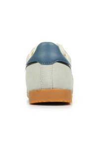 Sneaker con tomaia in suede grigio chiaro, accentuata da un tallone in pelle blu, striscia nera e suola in gomma naturale, vista dal retro.