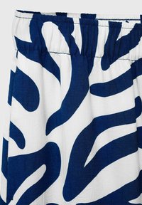 Blue and white patterned fabric features a wavy, abstract design. The texture appears soft with a slight sheen. Elastic waistband at the top.